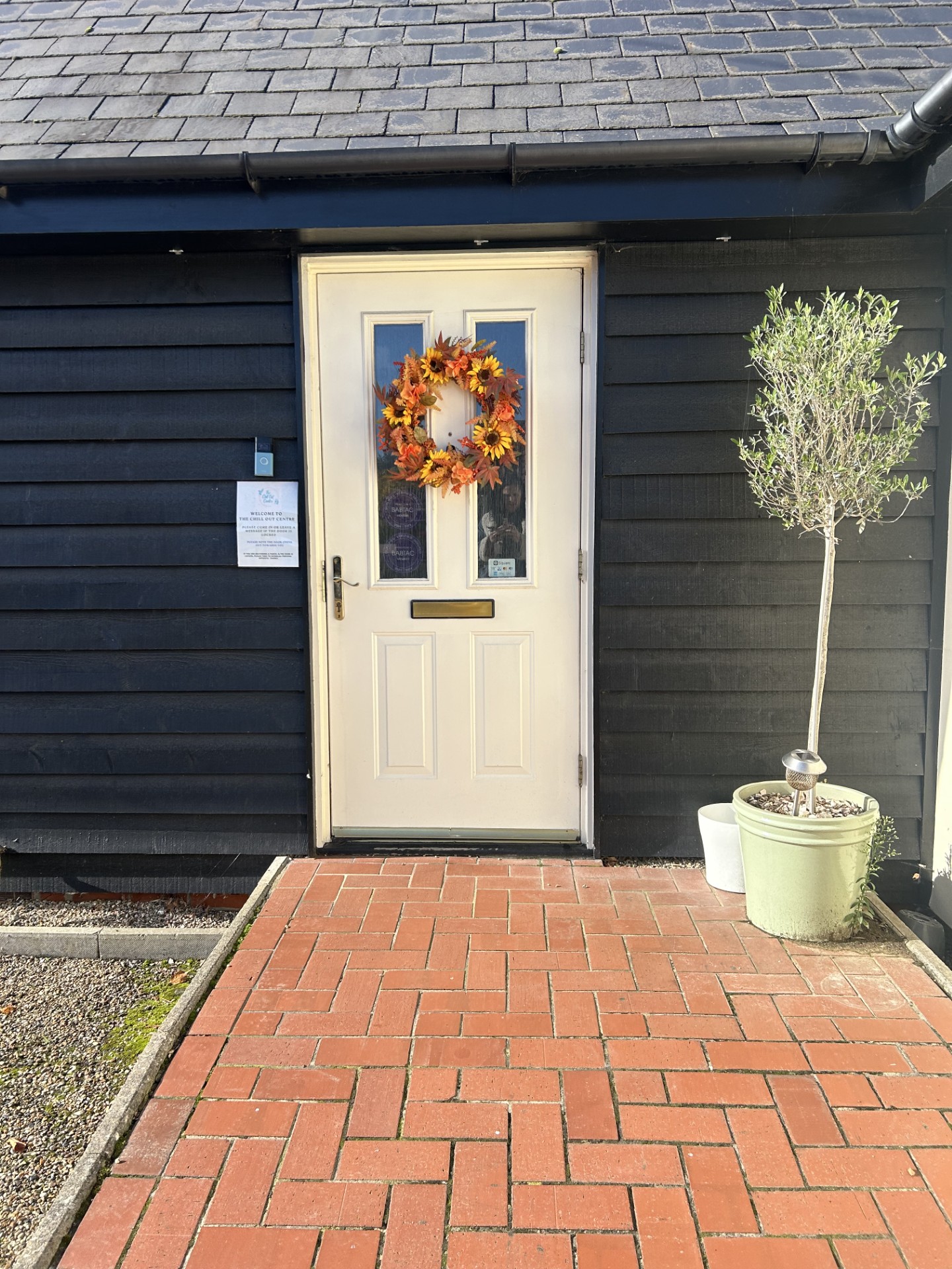 Cream front door of The Chill Out Centre with a seasonal wreath and welcome notice