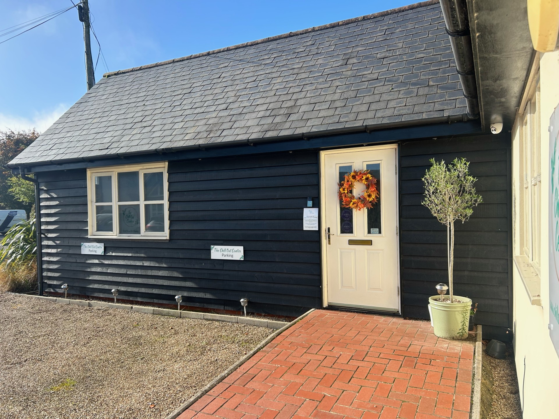 The Chill Out Centre, a black weatherboarded building with parking signs and a bright entrance